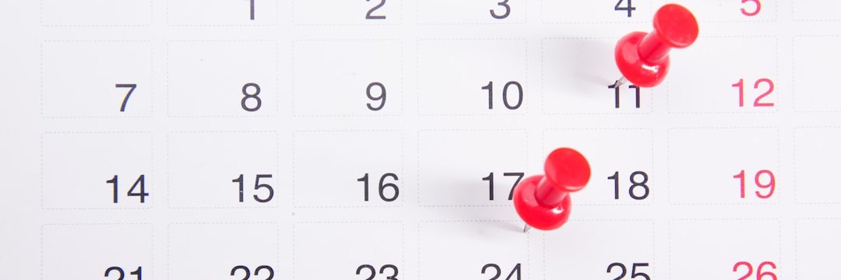 a calendar with red push buttons pinned to it