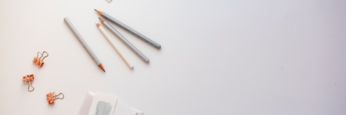 high angle photo of four pencils and greeting card