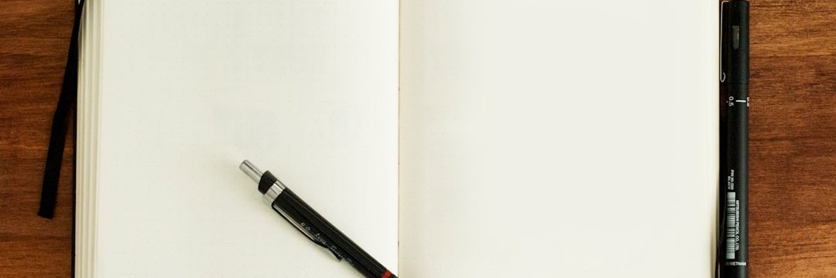 black and silver retractable pen on blank book