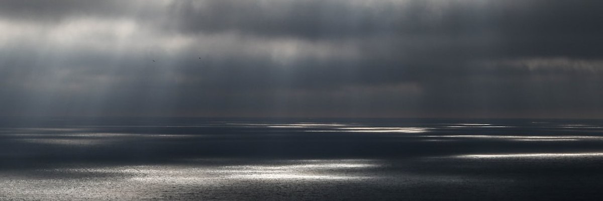 body of water under gray cloudy sky